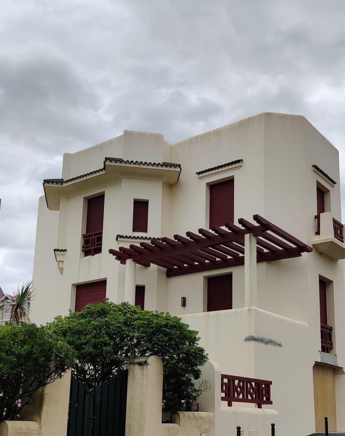 Stunning modern Basque-style house in Biarritz against a cloudy sky.