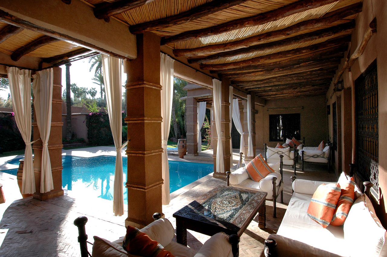Elegant patio with soft seating overlooking a serene pool, ideal for relaxation.